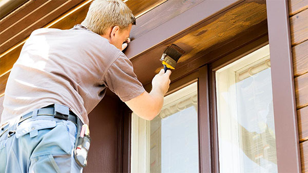 a man painting the inside trim of an outdoor window