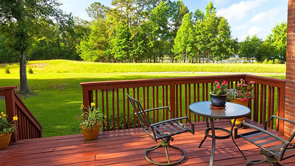 backyard house deck with a table and two chairs overlooking a yard